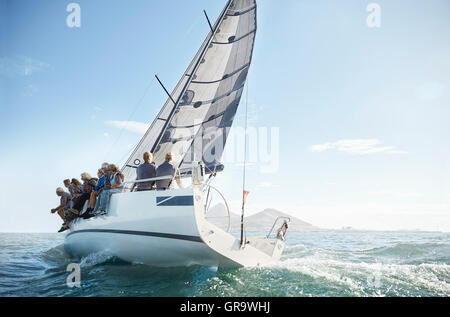 Retired friends on sailboat under blue sky Stock Photo