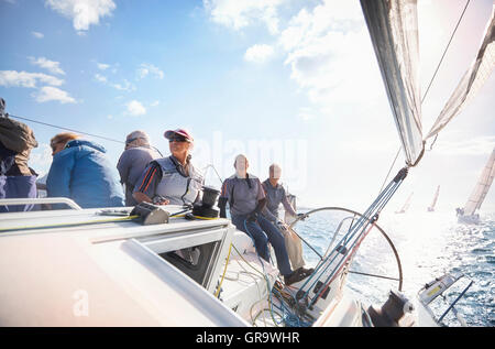 Retired friends on sailboat on sunny ocean Stock Photo