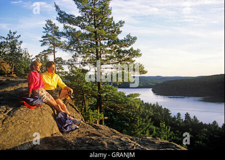 North America, Canada, Ontario, Algonquin Provincial Park, couple sitting on rock enjoying view Stock Photo