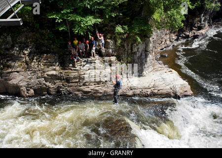 North America, Canada, Quebec, Beaupre, Canyon Ste-Anne, rock climbers crossing river on cable Stock Photo