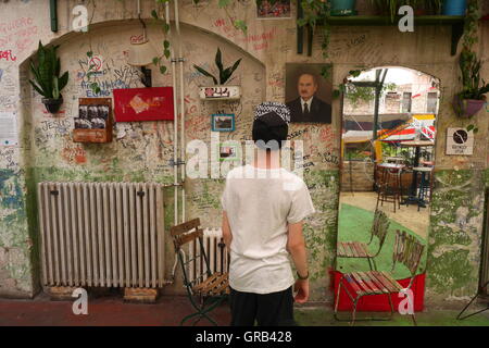 Teenage boy looking at art work and graffiti in the Szimpla kert Ruin Bar, Budapest, Hungary