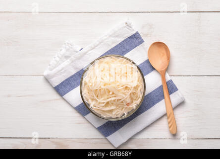 Top view of sauerkraut in glass bowl on white wooden  table Stock Photo