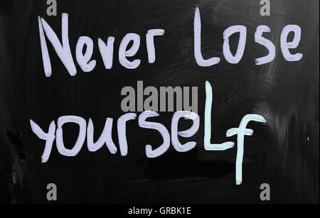 Never lose yourself handwritten with white chalk on a blackboa Stock Photo