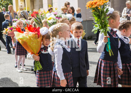 NOVOKUZNETSK, KEMEROVO REGION, RUSSIA - SEP, 1, 2016: Meeting with the first-grade pupils and teacher at schoolyard. The day of Stock Photo