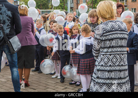 NOVOKUZNETSK, KEMEROVO REGION, RUSSIA - SEP, 1, 2016: Meeting with the first-grade pupils and teacher at schoolyard. The day of Stock Photo