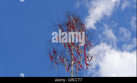 Maypole With Red Ribbons Under Blue Clouded Sky Stock Photo - Alamy