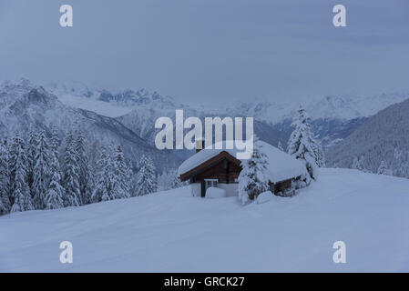 Landscape, Deeply Snow Covered, With Fir Trees And Chalet, At Dawn Stock Photo