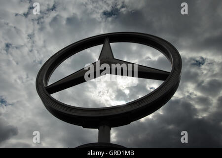 Mercedes Benz Sign With Dark Clouds Stock Photo