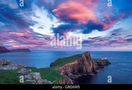Spectacular Red Sunset Clouds over Neist Point Lighthouse on the Isle of Skye in Scotland Stock Photo