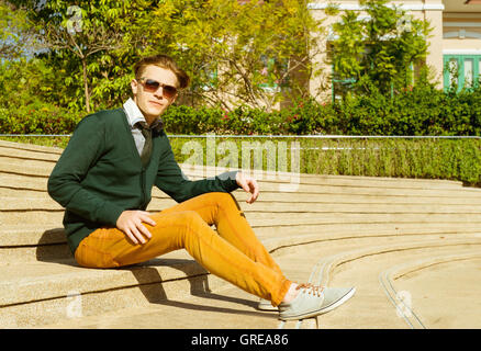 Man sits on yellow stairs Stock Photo