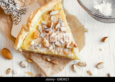 Piece of pie with nuts, seeds and mascarpone cheese on wooden background Stock Photo