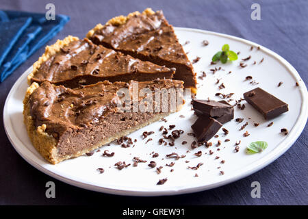 Homemade chocolate pie (cheesecake) on white plate close up Stock Photo