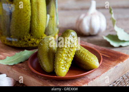 Homemade pickles on ceramic plate over rustic wooden background Stock Photo