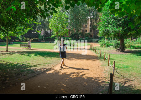 Young woman park, rear view of a young female traveler wearing a backpack walking through Gordon Square in Bloomsbury on a summer day, London, UK. Stock Photo