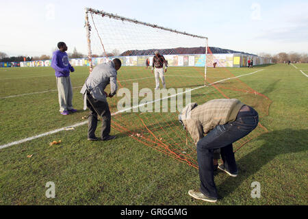 Irawo Reds FC players put up the goal nets before a Hackney & Leyton League Sunday Football match at East Marsh, Hackney Marshes Stock Photo