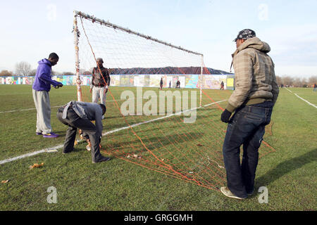 Irawo Reds FC players put up the goal nets before a Hackney & Leyton League Sunday Football match at East Marsh, Hackney Marshes Stock Photo