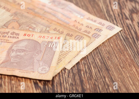 Ten rupee notes (Indian Currency) on wooden background Stock Photo