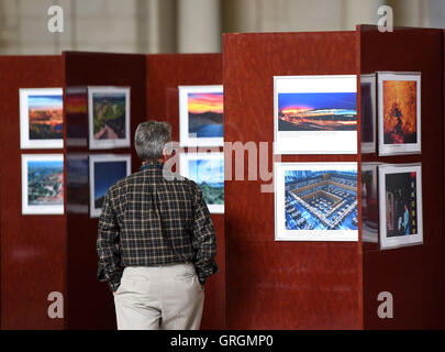 Washington, DC, USA. 6th Sep, 2016. A man views pictures at Charming Beijing Photo Exhibition at the main hall of the Union Station of Washington, DC, the United States, Sept. 6, 2016. The exhibition called Charming Beijing, which will last for four days, was held by the Beijing municipal government to celebrate 'China-U.S. Tourism Year' and to introduce Beijing's tourist attractions to local people. © Yin Bogu/Xinhua/Alamy Live News Stock Photo