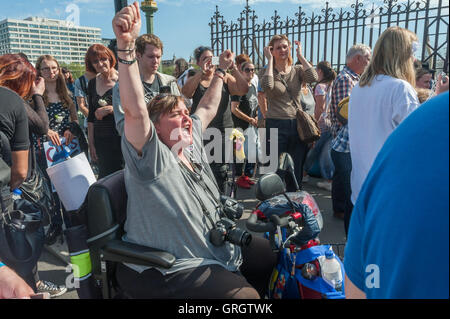 London, UK. 7th September, 2016. Paula Peters of DPAC greets the end of the 'No More Benefit Deaths' protest by disabled campaigners calling for an end to the sanctions and cuts in benefits that have led to many deaths which has blocked Westminster Bridge for almost two hours. Credit:  Peter Marshall/Alamy Live News Stock Photo