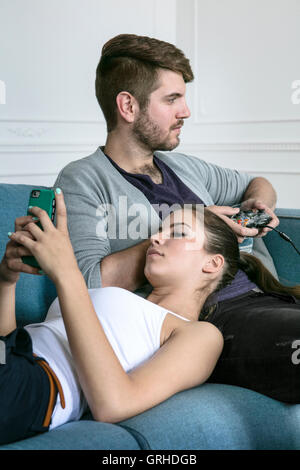A young couple play a game on a console or computer game and relax together and have fun Stock Photo