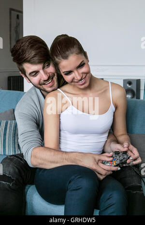 A young couple play a game on a console or computer game and relax together and have fun Stock Photo