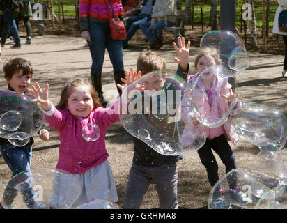 Children playing with soap bubbles during the excursion to the south side of River Thames Stock Photo