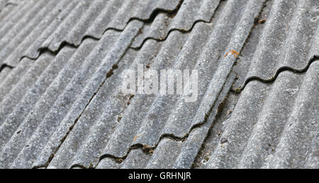 Old gray corrugated fibre cement roofing, background photo with selective focus Stock Photo