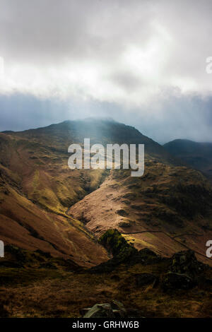 sun shard lighting mountains in lake district, National Park in Cumbria England UK Stock Photo