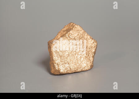 Golden nugget on gray background Stock Photo