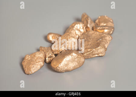 Golden nuggets on gray background Stock Photo