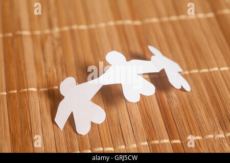 White paper people on wooden background Stock Photo