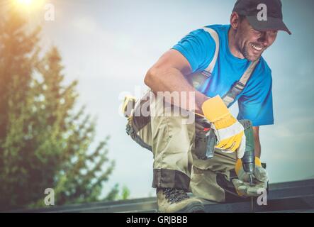Happy Construction Worker Smiling While Working on Wooden Roof. Satisfied Worker. Stock Photo