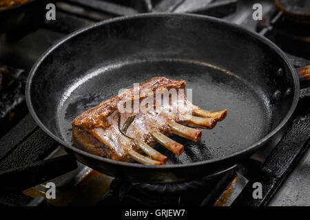 Rack of lamb frying in the pan Stock Photo