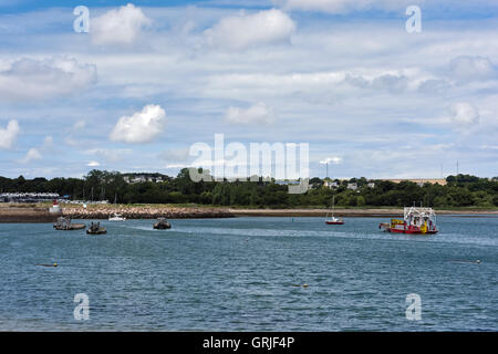 Paimpol bay at high water with moored oyster boats and yacht departing Stock Photo