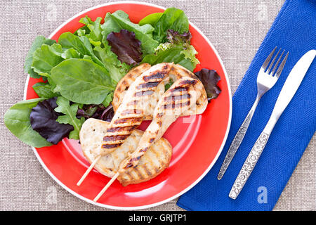 Delicious grilled meat on stick with healthy vegetables on a plate Stock Photo