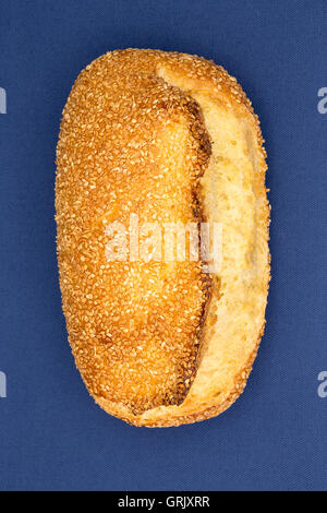 Close up overhead view of a freshly baked crusty golden sesame seed bread loaf showing the texture of the crust and roasted seed Stock Photo