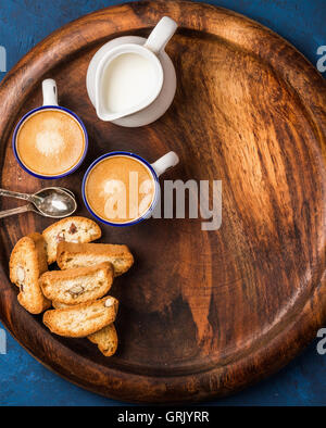 Coffee espresso, cookies and milk on wooden serving round board Stock Photo