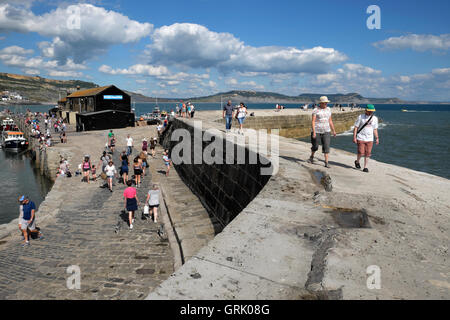 People walking on the Cobb on a sunny summer day at Lyme Regis, Dorset, England UK  KATHY DEWITT