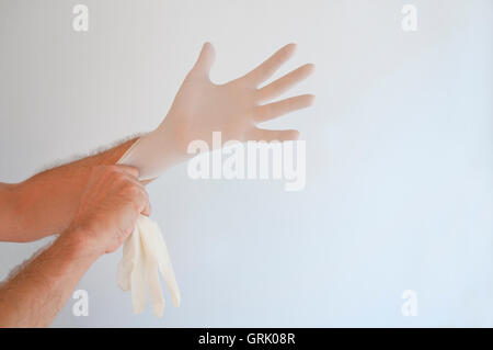 Man putting his latex gloves on. Stock Photo