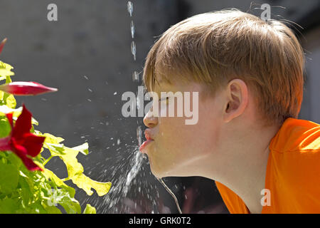young boy drinking from fountain Stock Photo