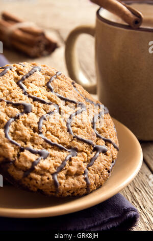 Homemade oatmeal cookies with chocolate and cup of coffee over rustic wooden background Stock Photo