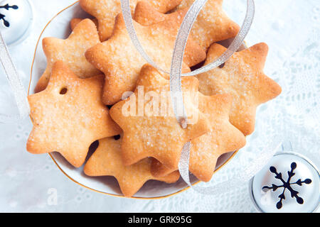 Gingerbread Christmas cookies on white napkin with silver ribbon for winter holidays Stock Photo