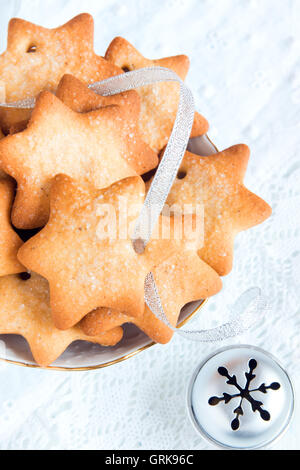 Gingerbread Christmas cookies on white napkin with silver ribbon for winter holidays Stock Photo