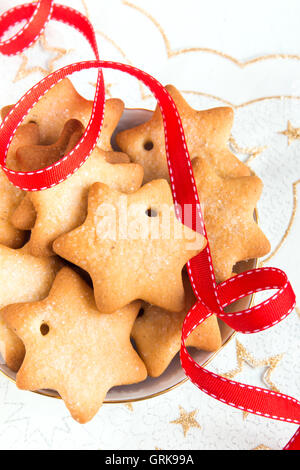 Gingerbread Christmas cookies on white napkin with stars and red ribbon for winter holidays