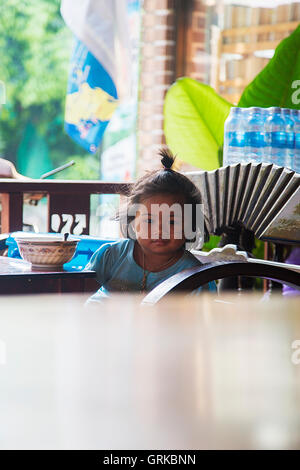 KO PHA NGAN - FEBRUARY 6, 2016: Unidentified girl in restaurant at Ko Pha Ngan island in Thailand. Island is part of the Samui A Stock Photo