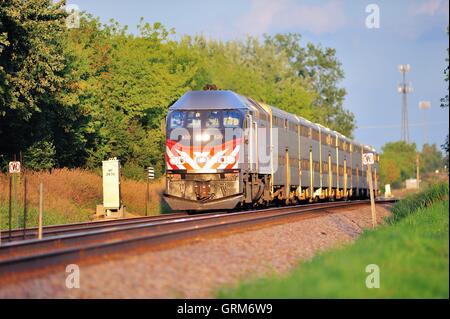 A Metra commuter train thundering through Bartlett, Illinois on a line connecting Chicago with Elgin, Illinois. USA. Stock Photo