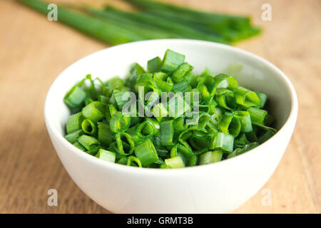 Chopped chives in white bowl, organic ingredient for cooking Stock Photo