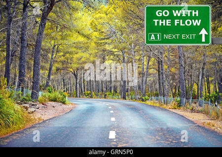 GO WITH THE FLOW road sign against clear blue sky Stock Photo