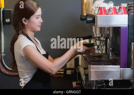 Female bartender makes coffee using coffee machine. Stock Photo