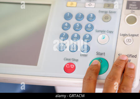 Closeup fingers pressing display buttons on photocopier Stock Photo